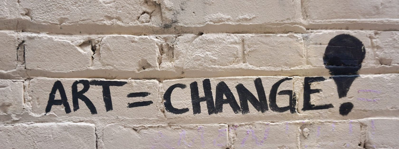 Graffiti on a brick wall that reads ART=CHANGE!
