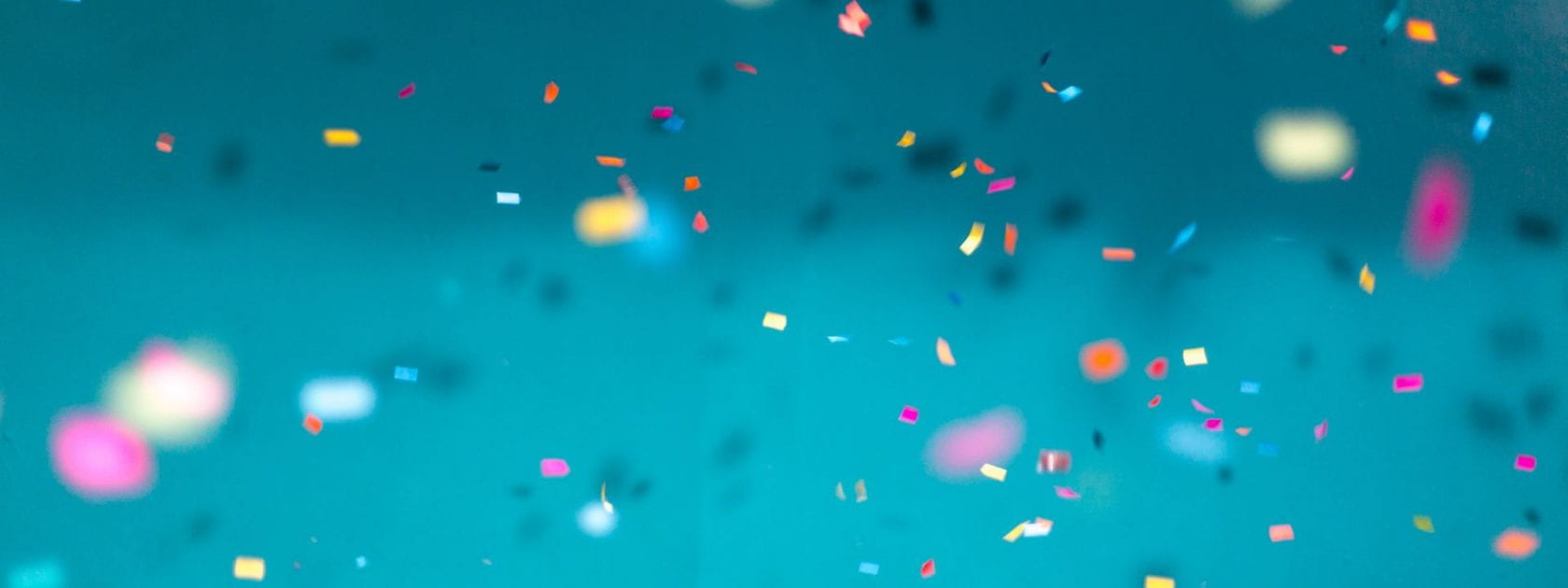 Image shows colour confetti on a blue background.